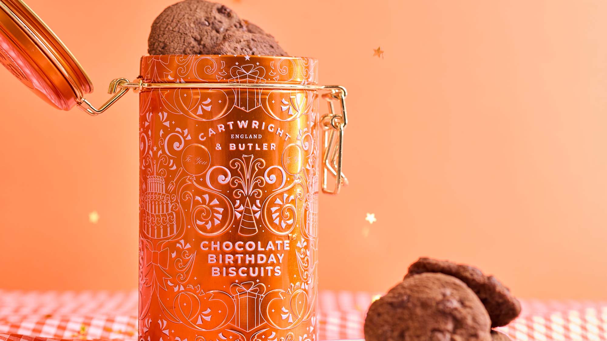Cartwright & Butler chocolate birthday biscuits in orange decorative tin with chocolate biscuits displayed