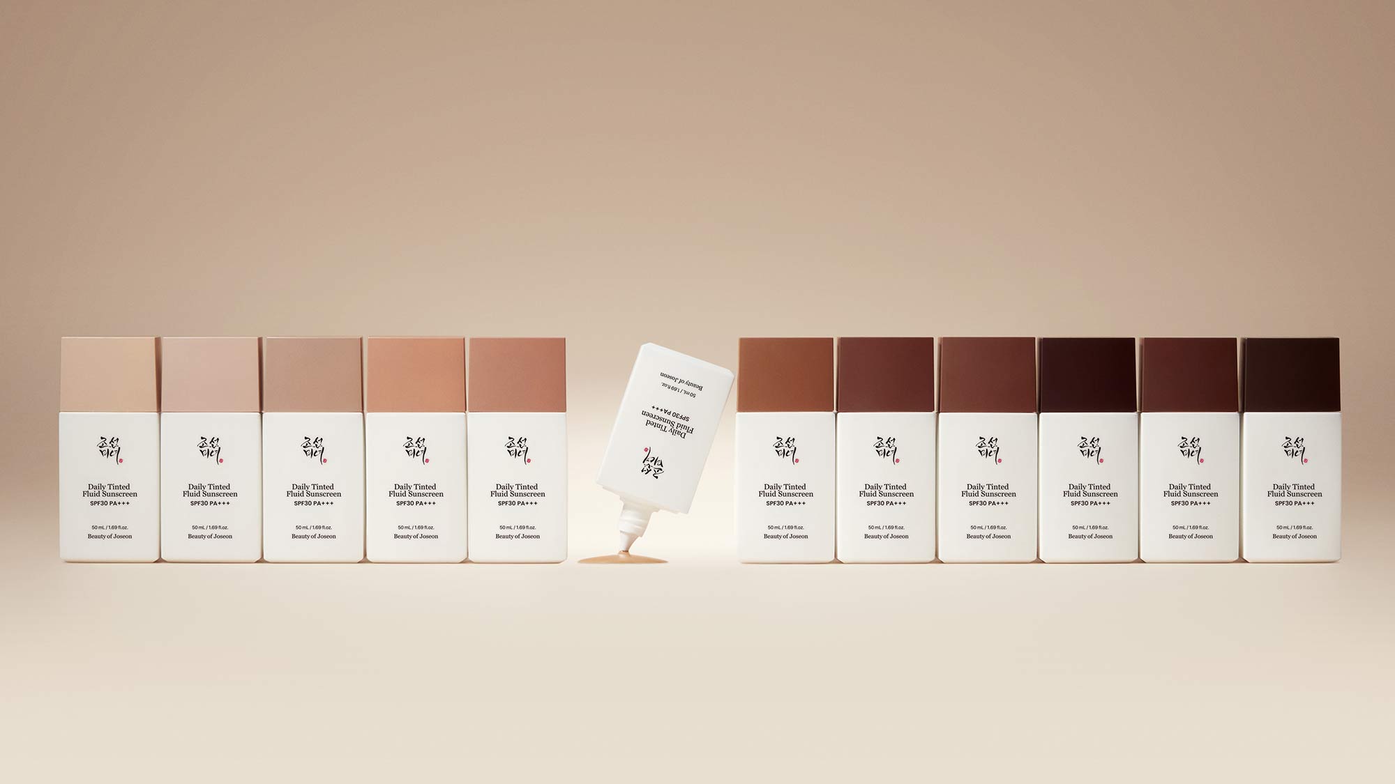Range of Daily Tinted Fluid Sunscreen bottles with varying shade depths from light to dark, displayed in rows with one open tube in centre