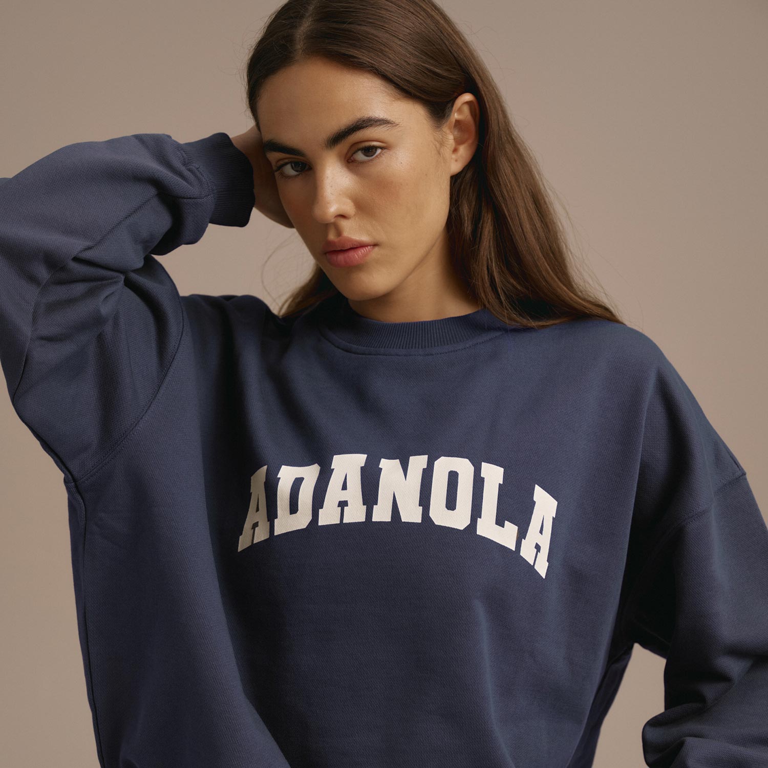 Woman in a navy blue sweatshirt with white text branding