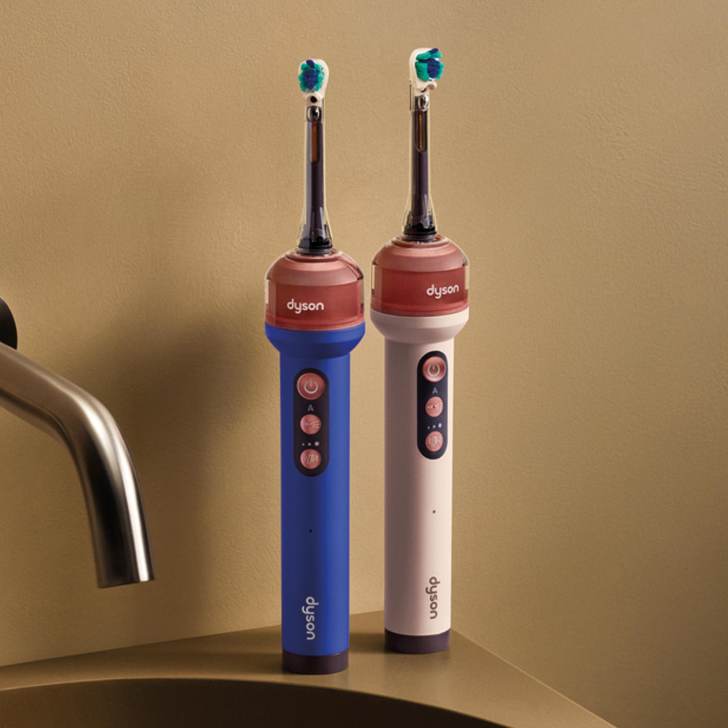 Two Dyson Camerajet electric toothbrushes in blue and pink with teal brush heads