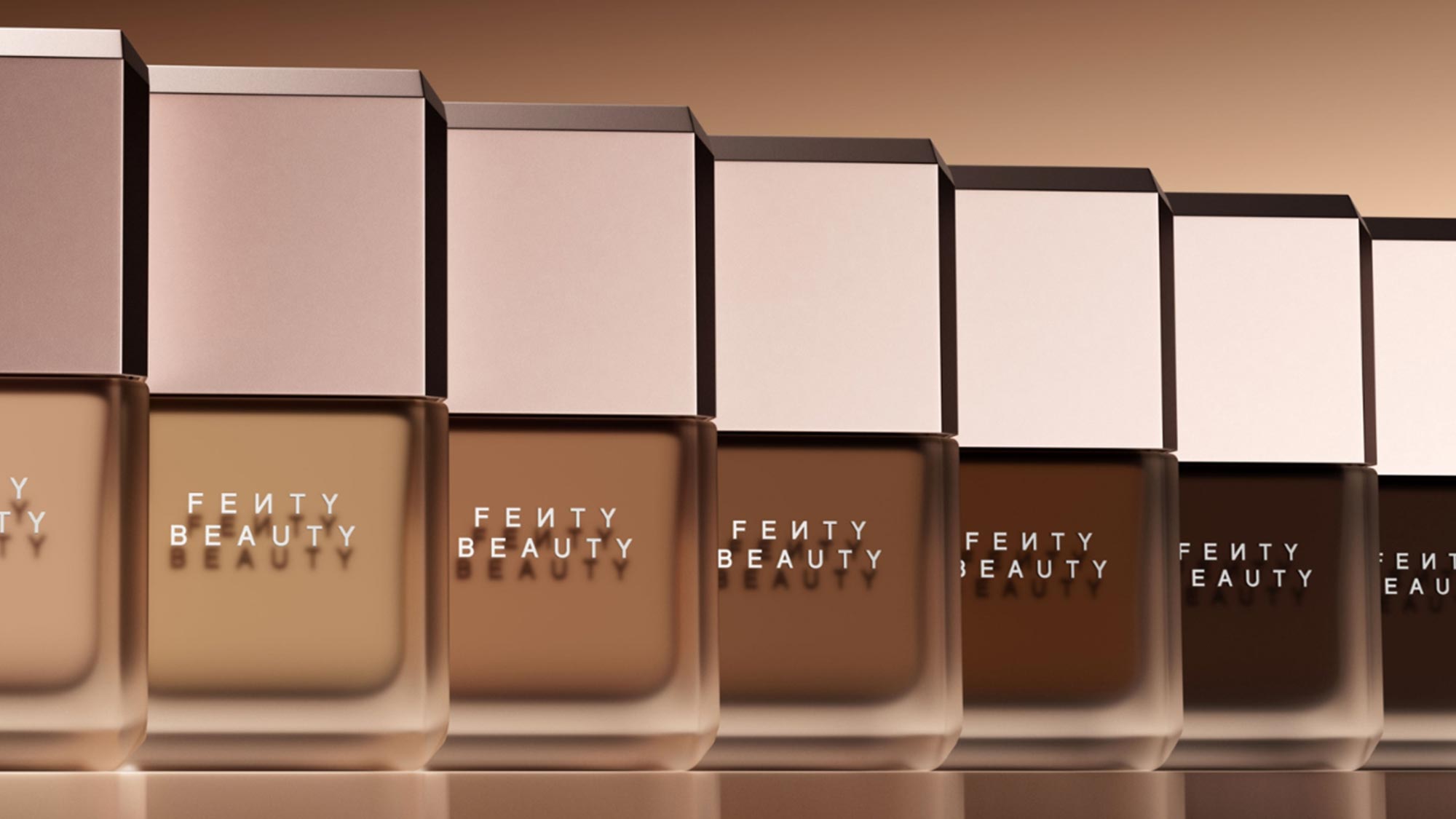 Row of Fenty Beauty Pro Filt'r Fluid Flex Foundation bottles in varying shades from light to dark