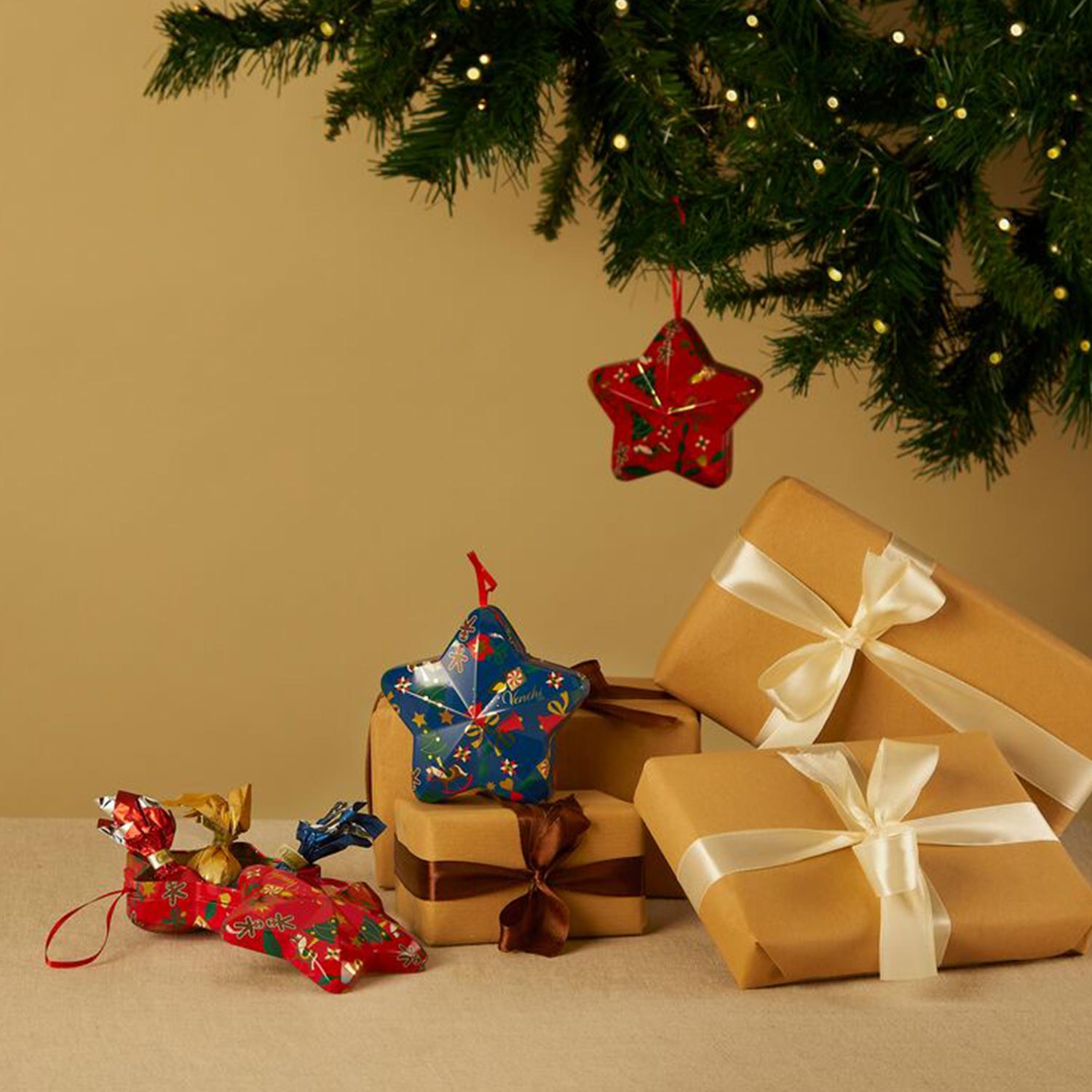 Hand holding festive chocolate advent calendar with red bow and gold seal, featuring holiday-themed illustrations