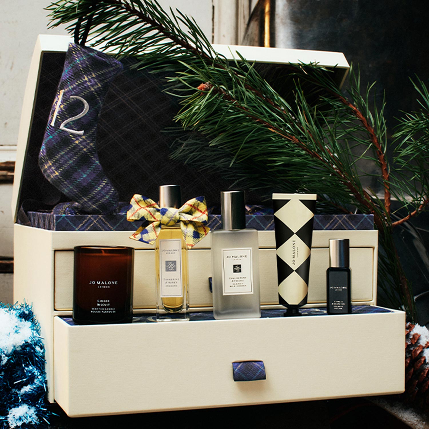Jo Malone London Wild Wash bottles with teal bows surrounded by decorative ceramic animal figurines on pale blue background