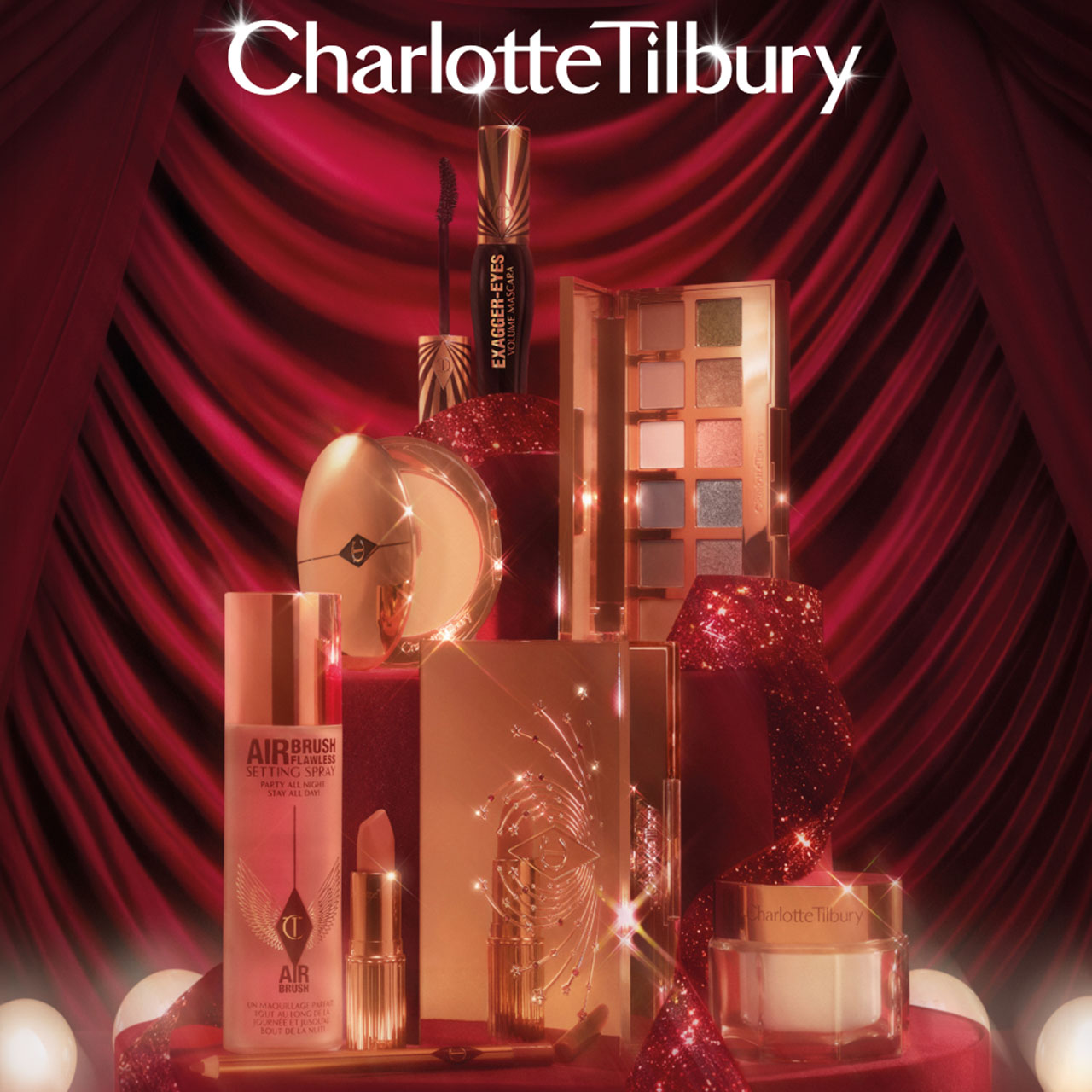 Charlotte Tilbury Christmas gift set featuring makeup and beauty products with two women models against red sparkly background.