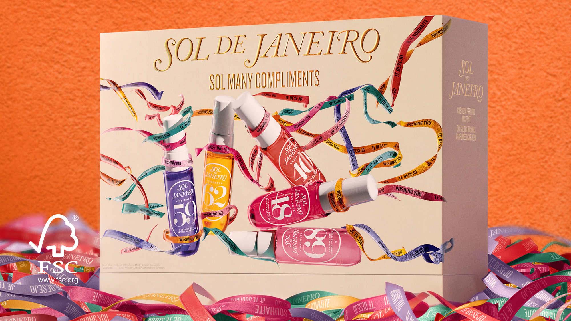 Sol de Janeiro Sol Many Compliments Christmas gift box with colourful body care bottles and festive ribbons on orange backdrop.