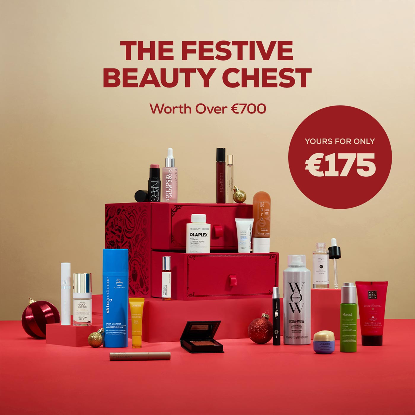 Red tiered gift chest filled with assorted beauty and skincare products, surrounded by festive baubles and cosmetics, worth over €700