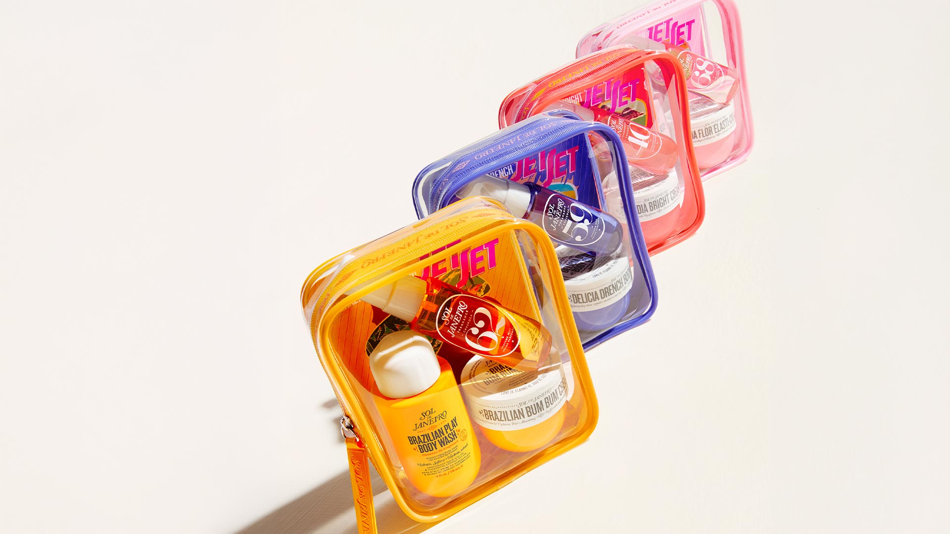 Sol de Janeiro JetSets collection in coloured clear pouches containing Brazilian body wash and moisturiser products.
