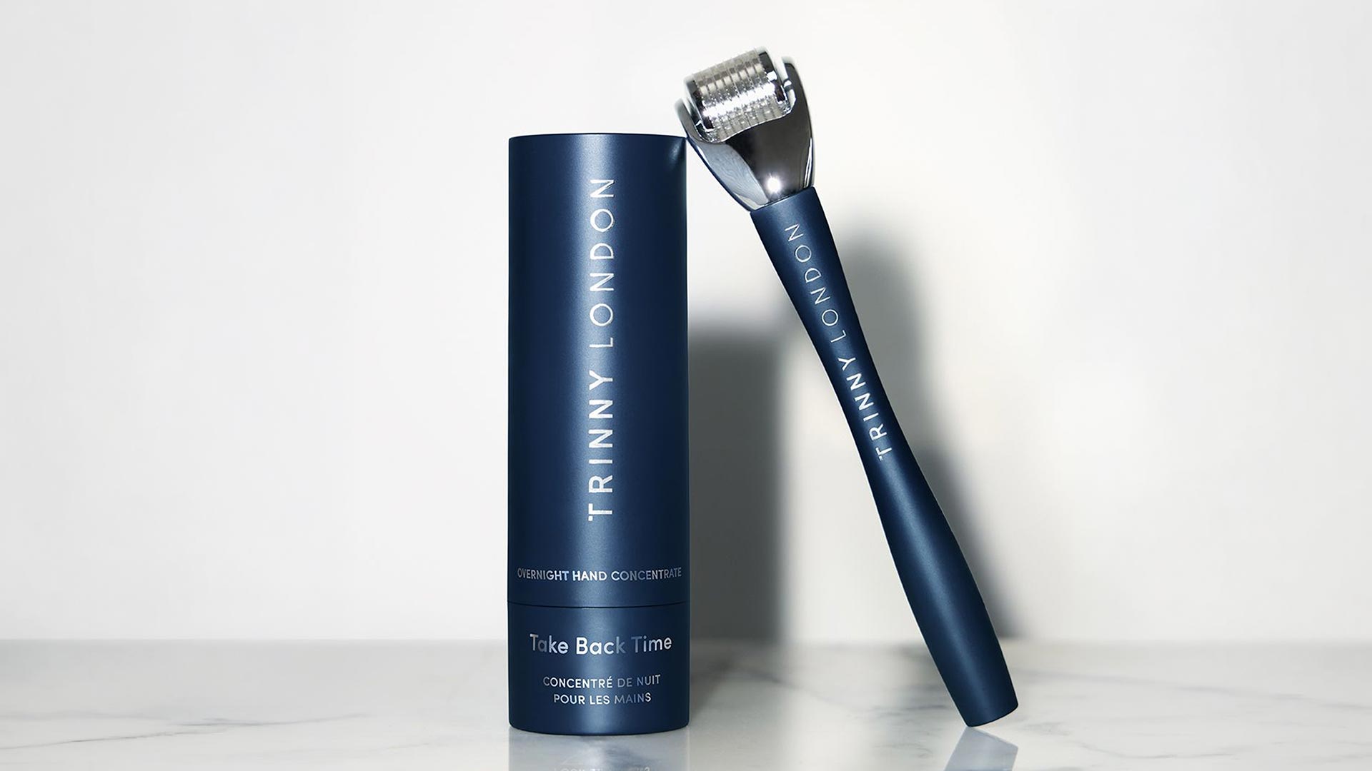 Trinny London overnight hand concentrate in dark blue tube with matching micropen applicator tool.