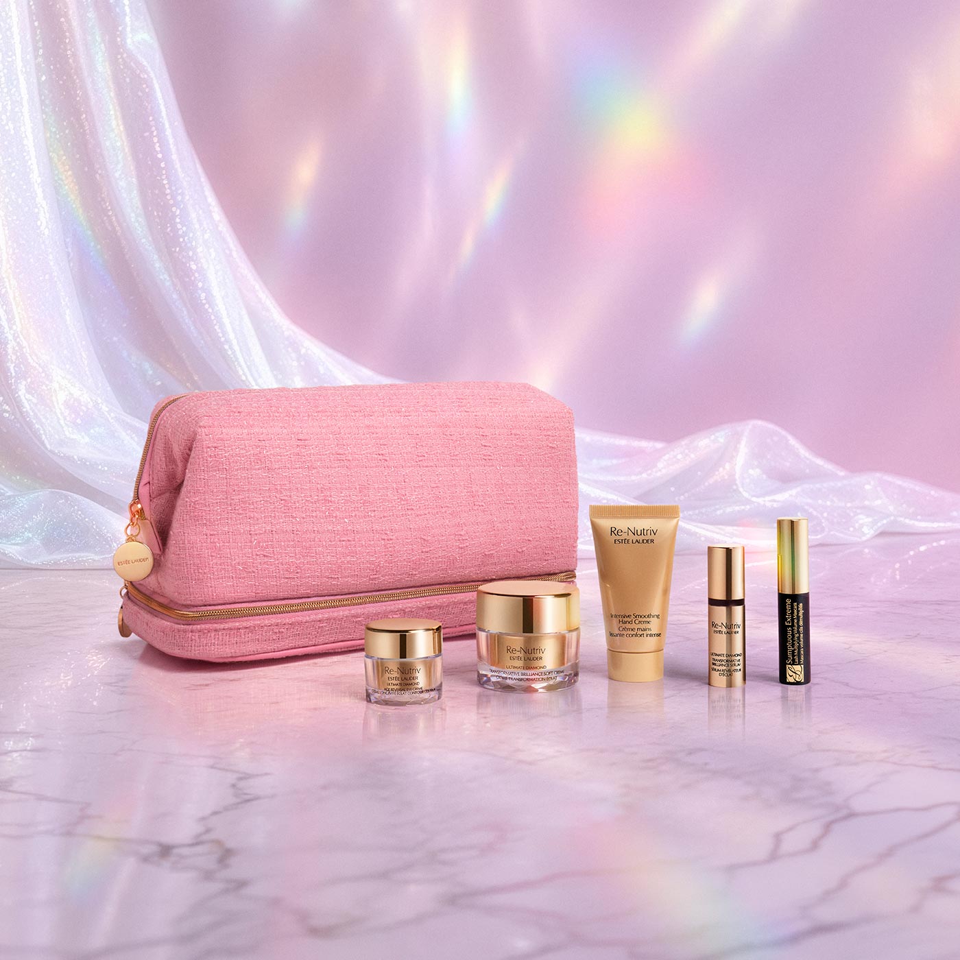 Pink cosmetic bag with gold zip, surrounded by Re-Nutriv skincare and makeup products with gold packaging on pink marble background
