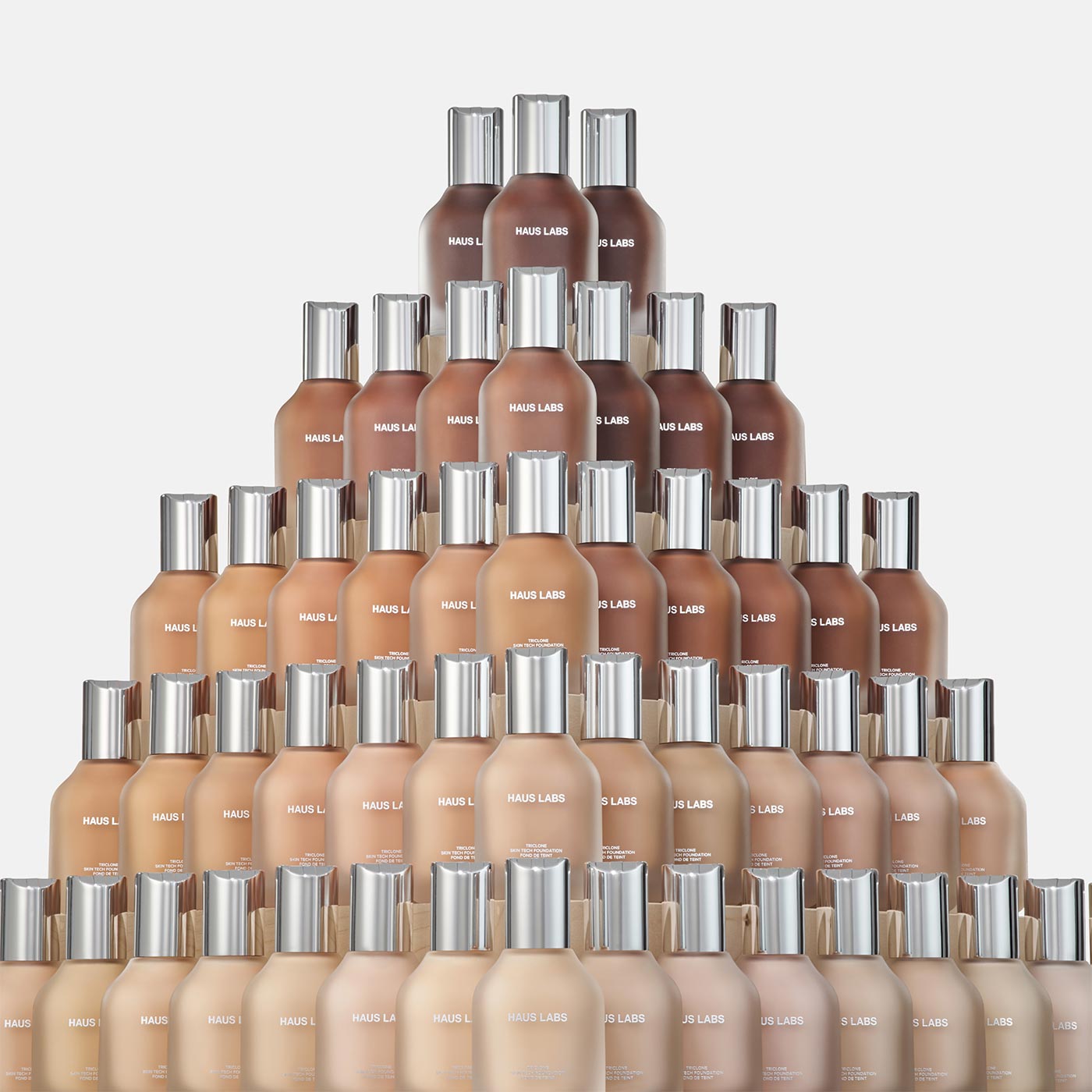 Pyramid display of Haus Labs Triclone Skin Tech Foundation bottles in multiple shade options
