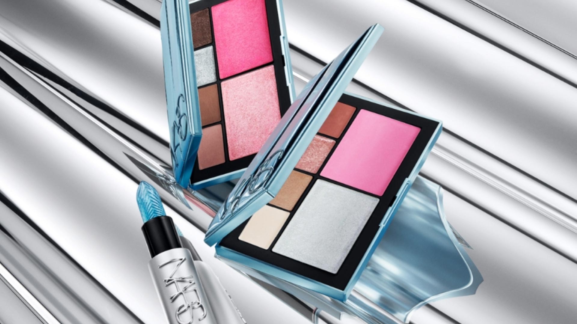 Two eyeshadow palettes with pink and neutral tones and a blue liquid eyeliner with black brush applicator