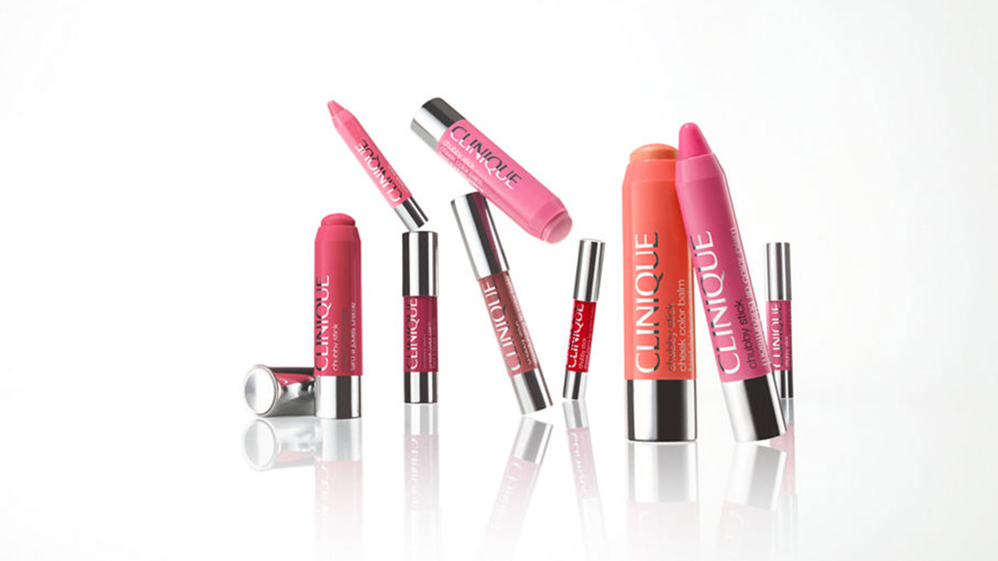 Woman in a shimmering, brown halter-neck dress and black heels, posing against a plain background.