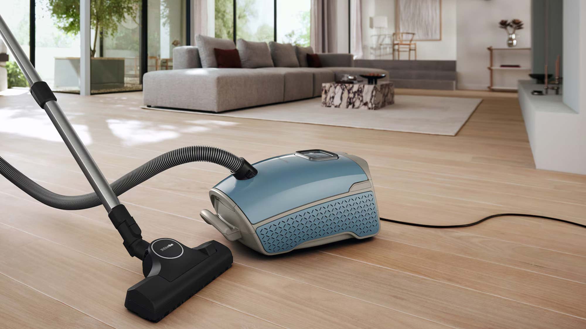 A woman docking a cordless vacuum cleaner onto a wall mount.