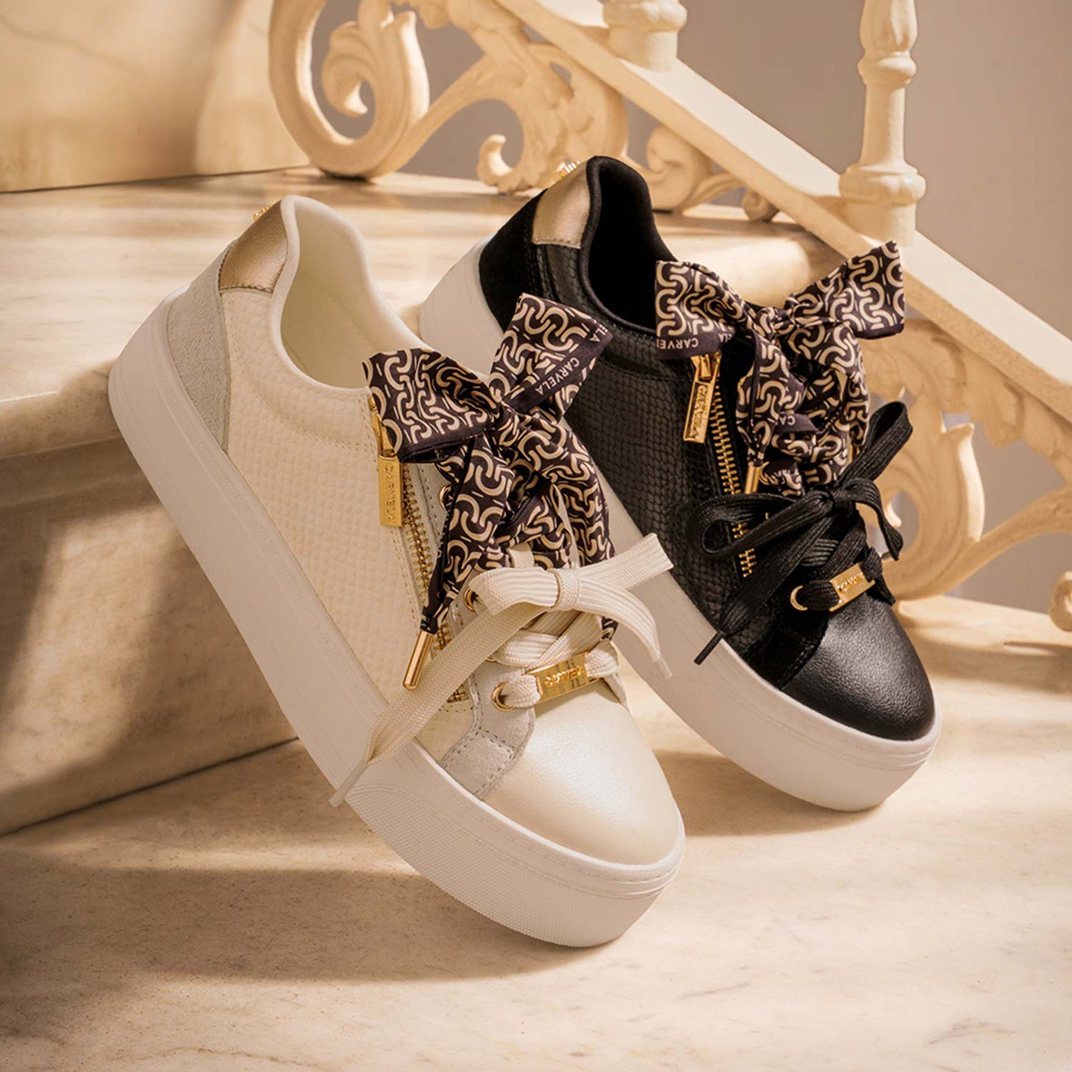 Two stylish sneakers, one white and one black, with patterned laces, placed on marble stairs.