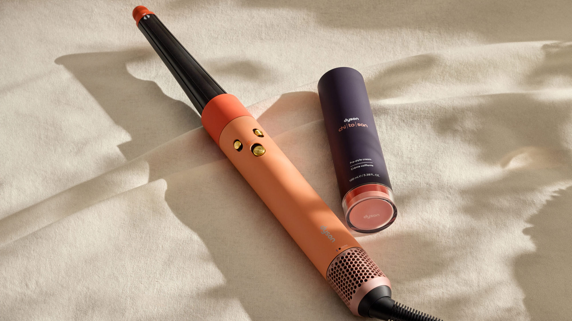 Dyson hair styling tools including orange hair dryer and hair care product