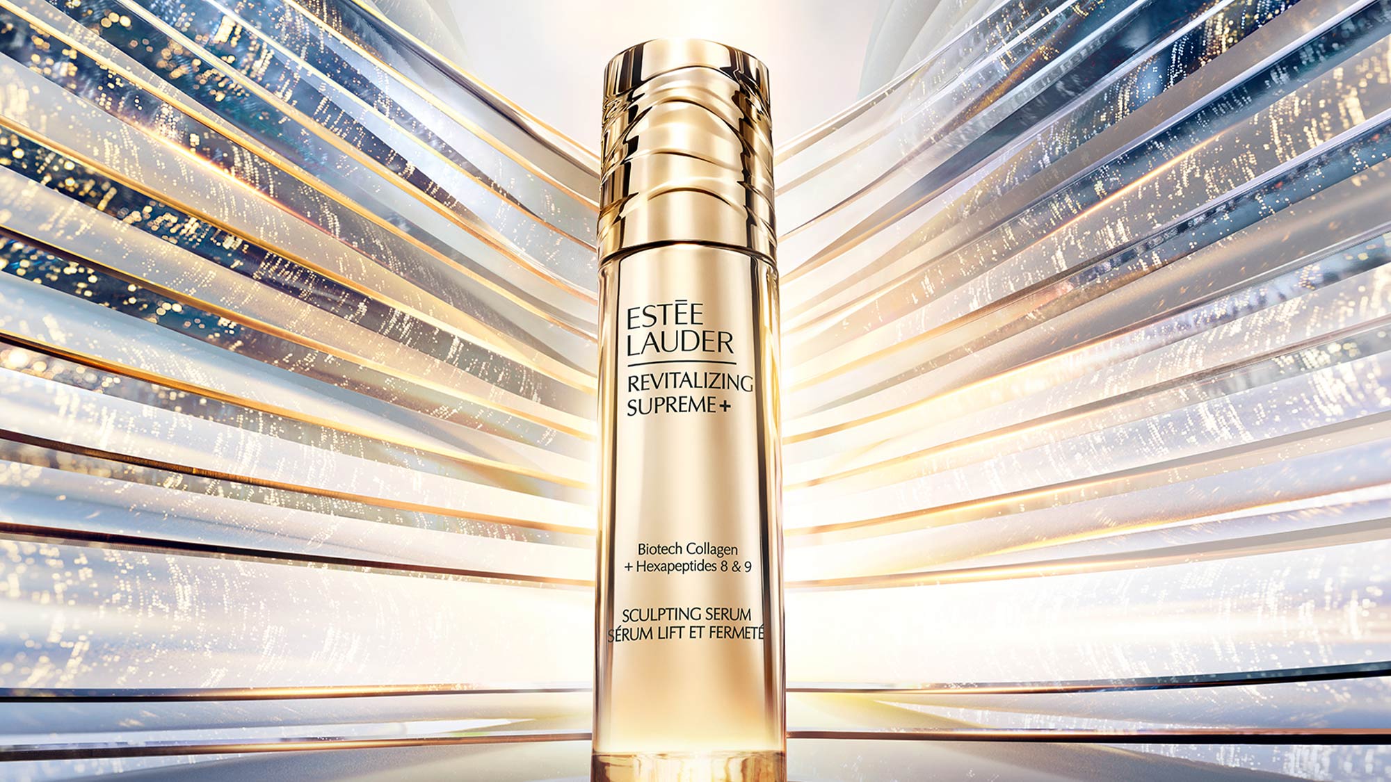 Estée Lauder Revitalizing Supreme+ Sculpting serum bottle with gold radiant light effect background