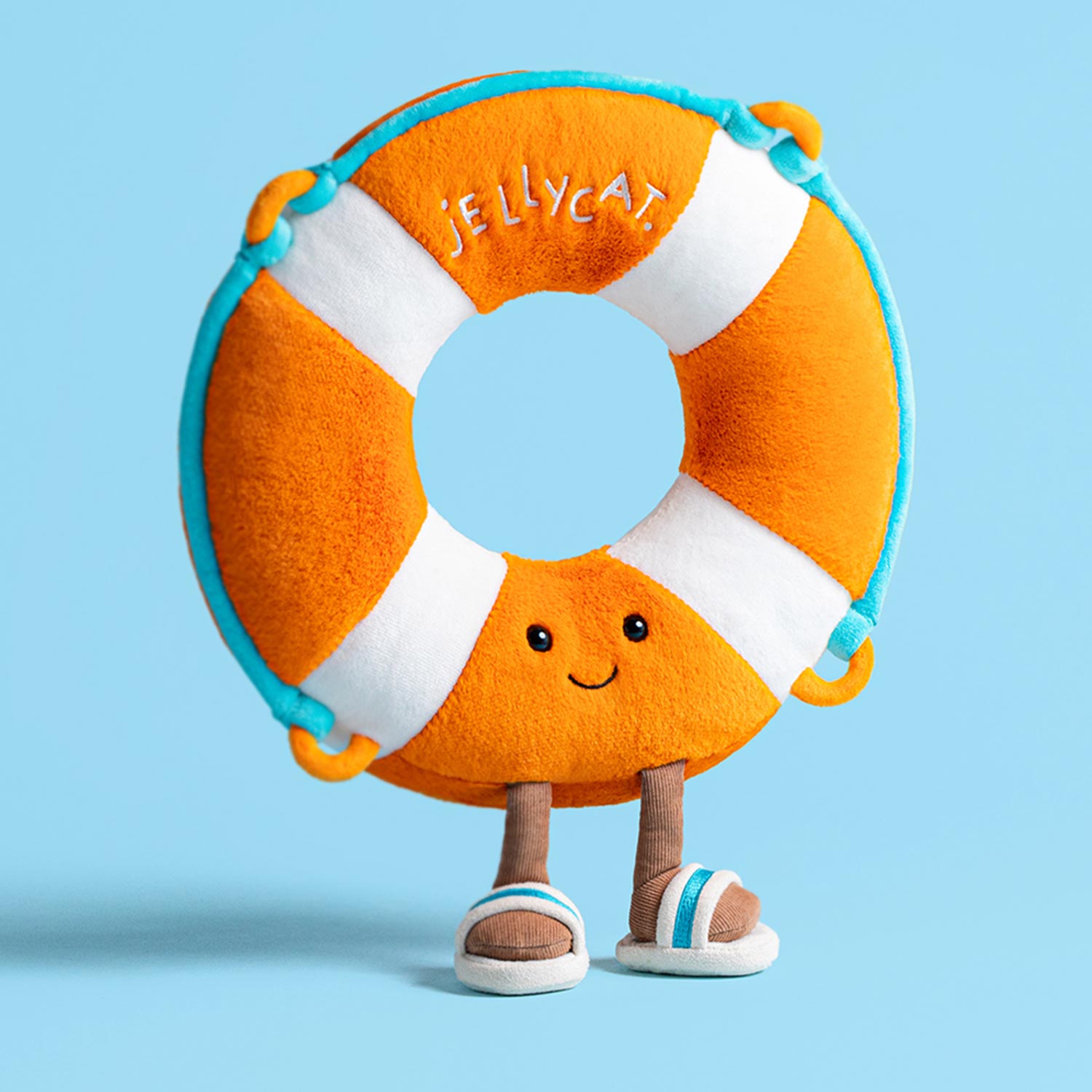 Orange and white plush life ring toy character with smiling face and outstretched arms against light blue background