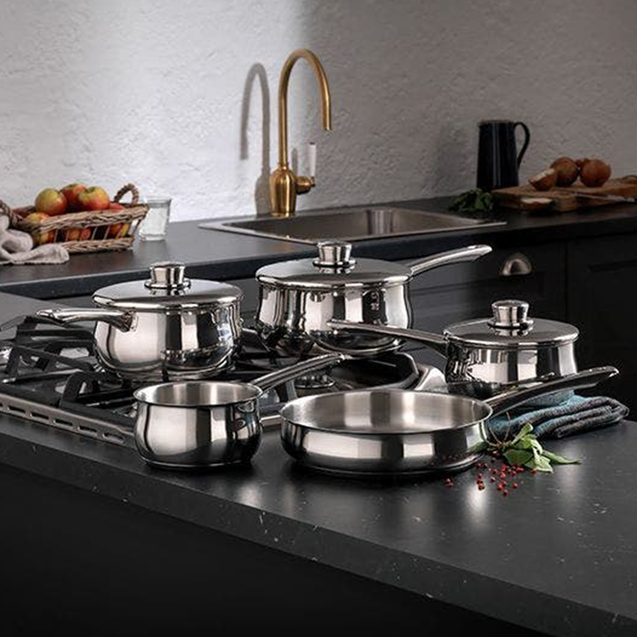 Stellar stainless steel cookware set on black stovetop, including pots and frying pans with lids