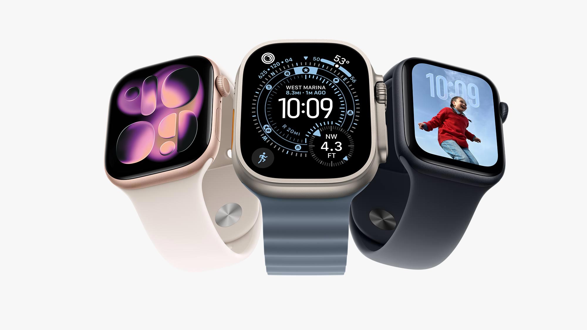 Three Apple Watches displaying different watch faces and colour options: pink with abstract design, beige with compass, black with photo of snowboarder
