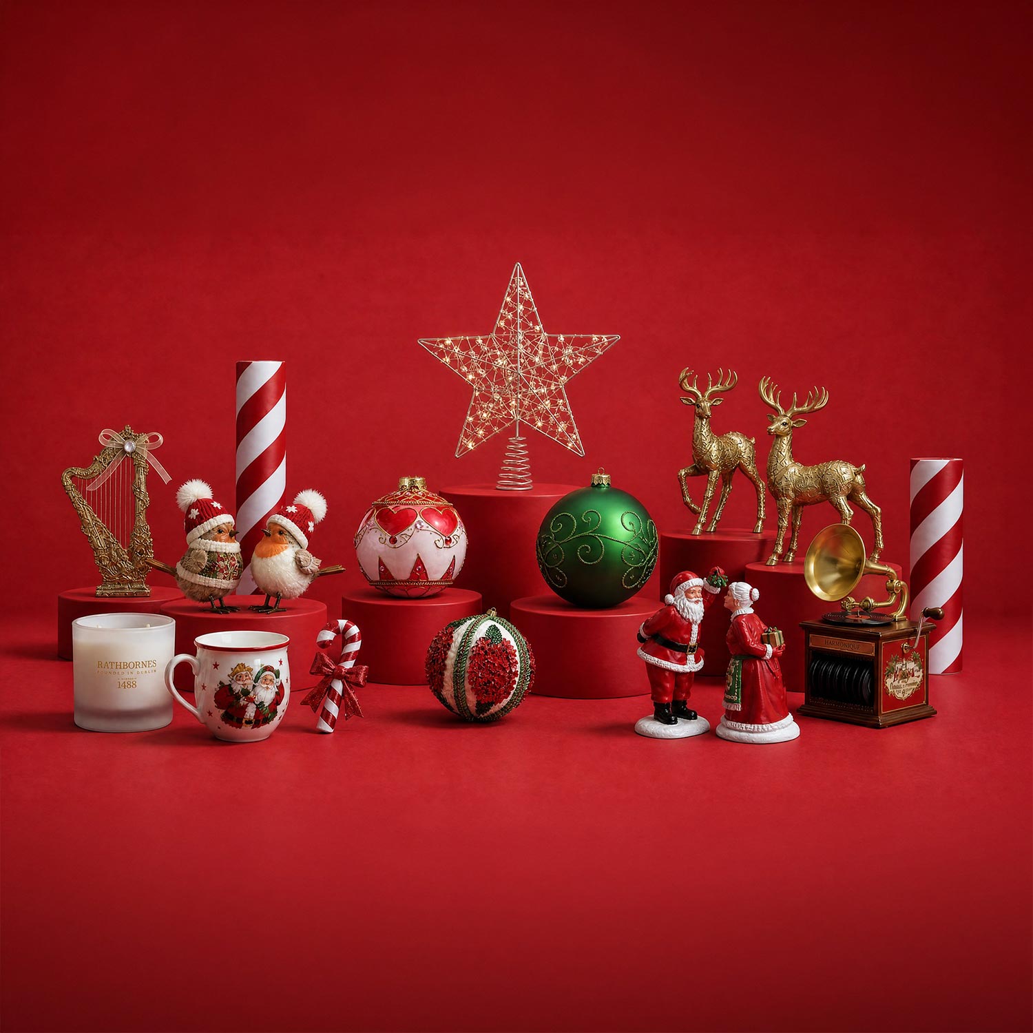 Christmas decorations collection including baubles, reindeer figurines, Santa figures, candles, and festive ornaments arranged on red display platforms