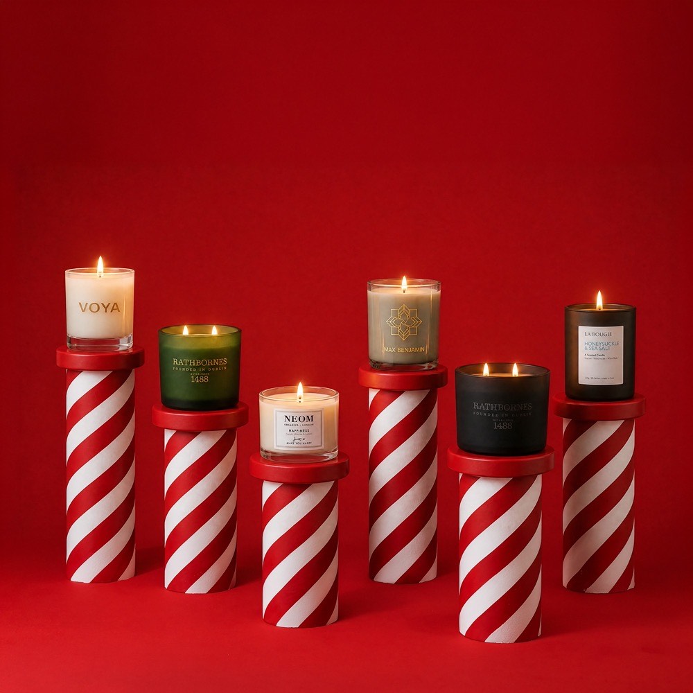 Luxury scented candles by Voya, Rathbornes, Neom and Max Benjamin on striped red and white bases