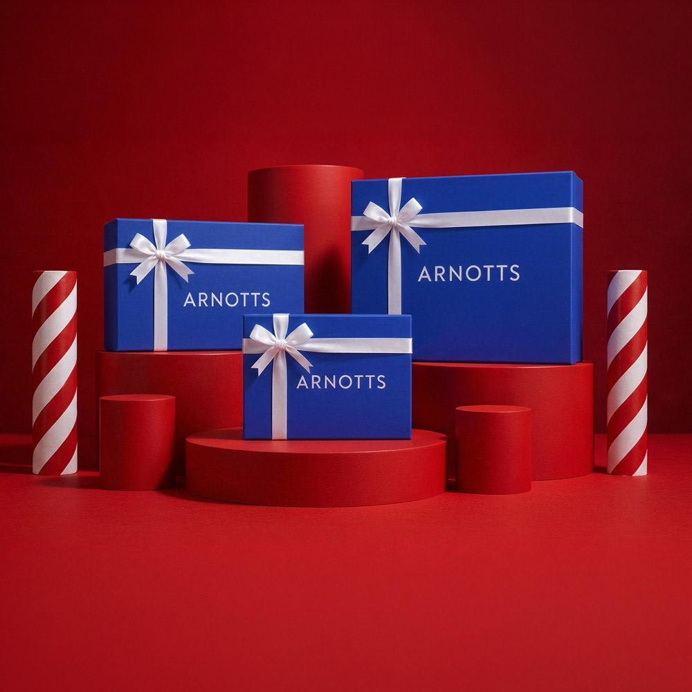 Blue gift boxes with white ribbon bows surrounded by red cylindrical pedestals and red and white striped candles