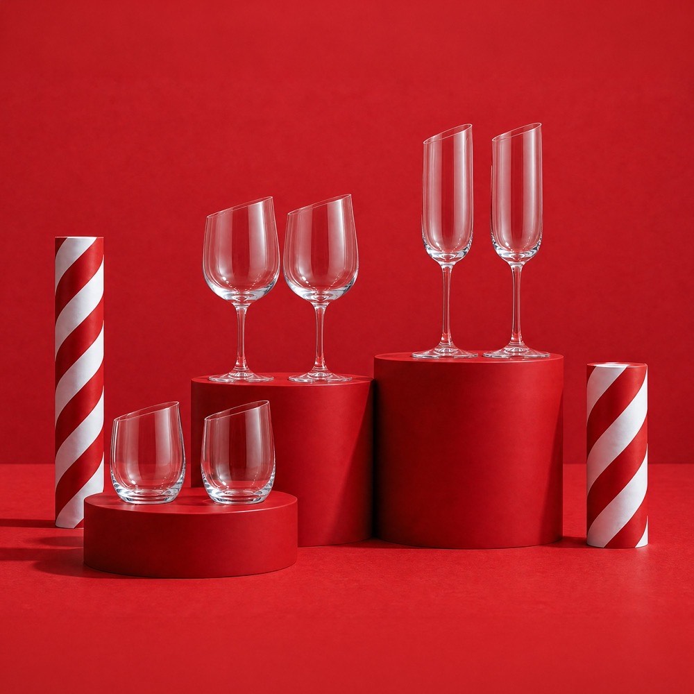 Set of crystal wine glasses and champagne flutes displayed on red cylindrical platforms
