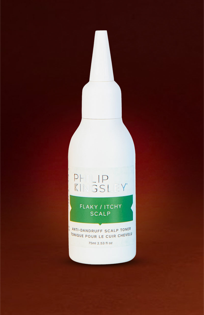White bottle with a pointed nozzle, labeled 'Philip Kingsley Flaky/Itchy Scalp.' Set against a dark red gradient background.