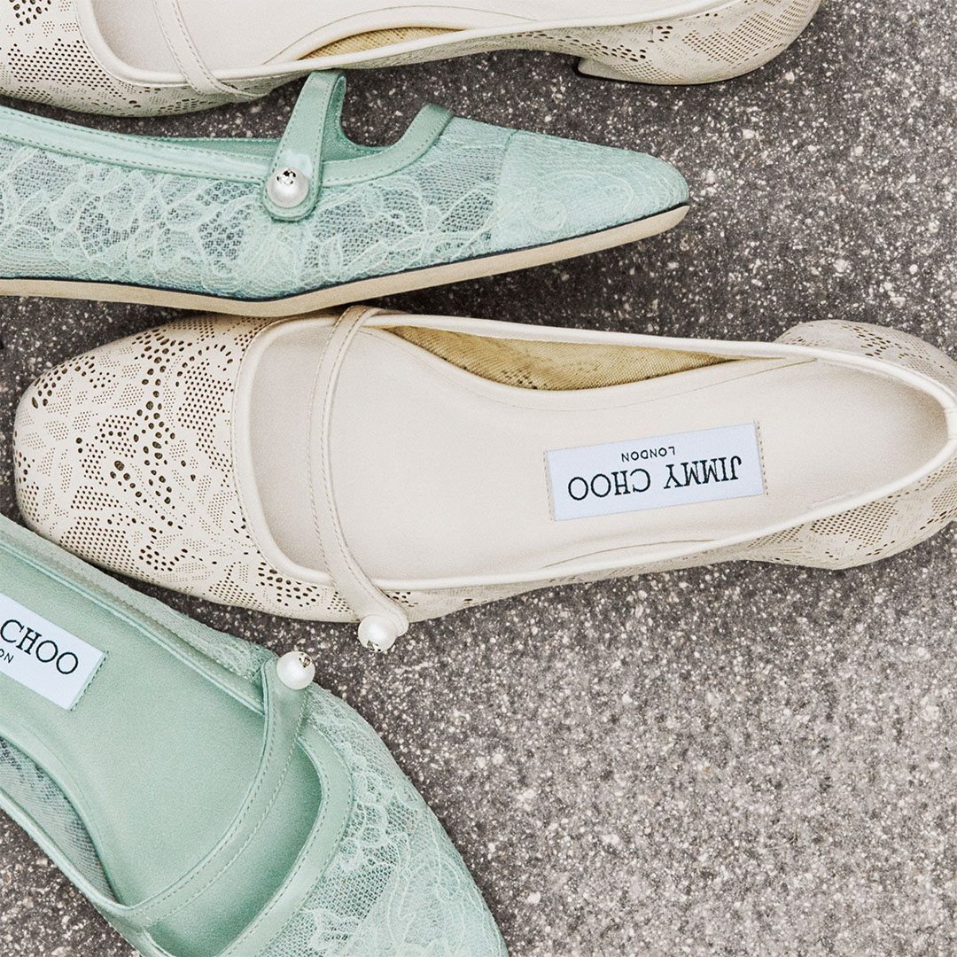 Light blue Prada slides rest on a reflective surface, showcasing their quilted design and branding.