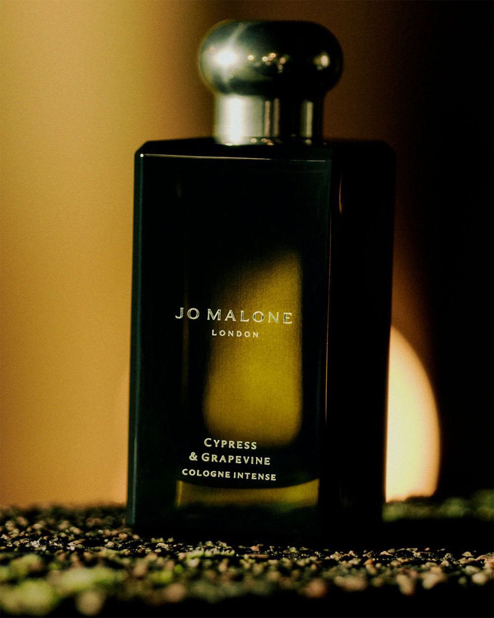 A bottle of Jo Malone perfume on a marble surface.