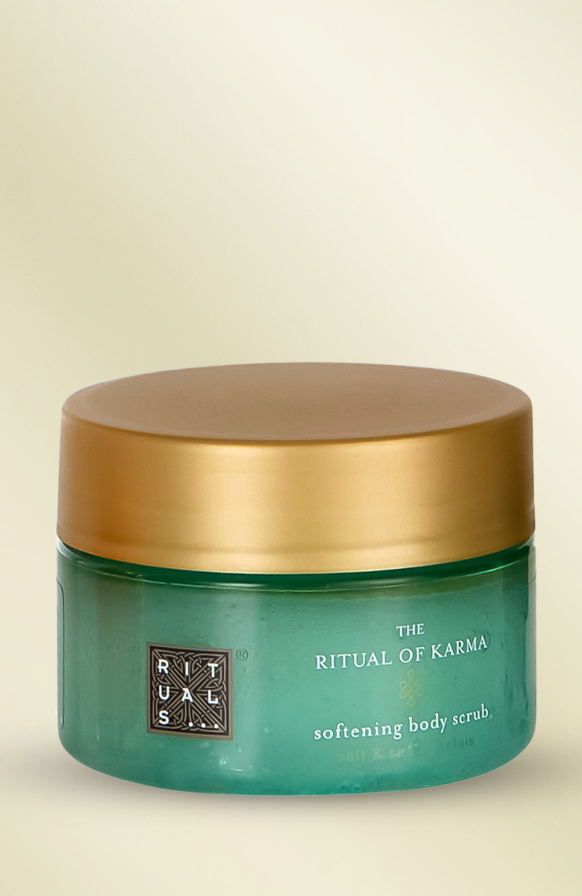 A green jar of 'The Ritual of Karma' softening body scrub with a gold lid.