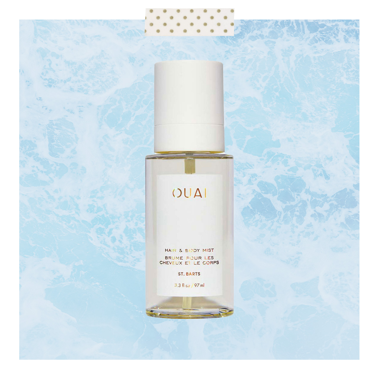 Clear hair and body mist spray bottle with white cap and gold branding on blue water-textured background