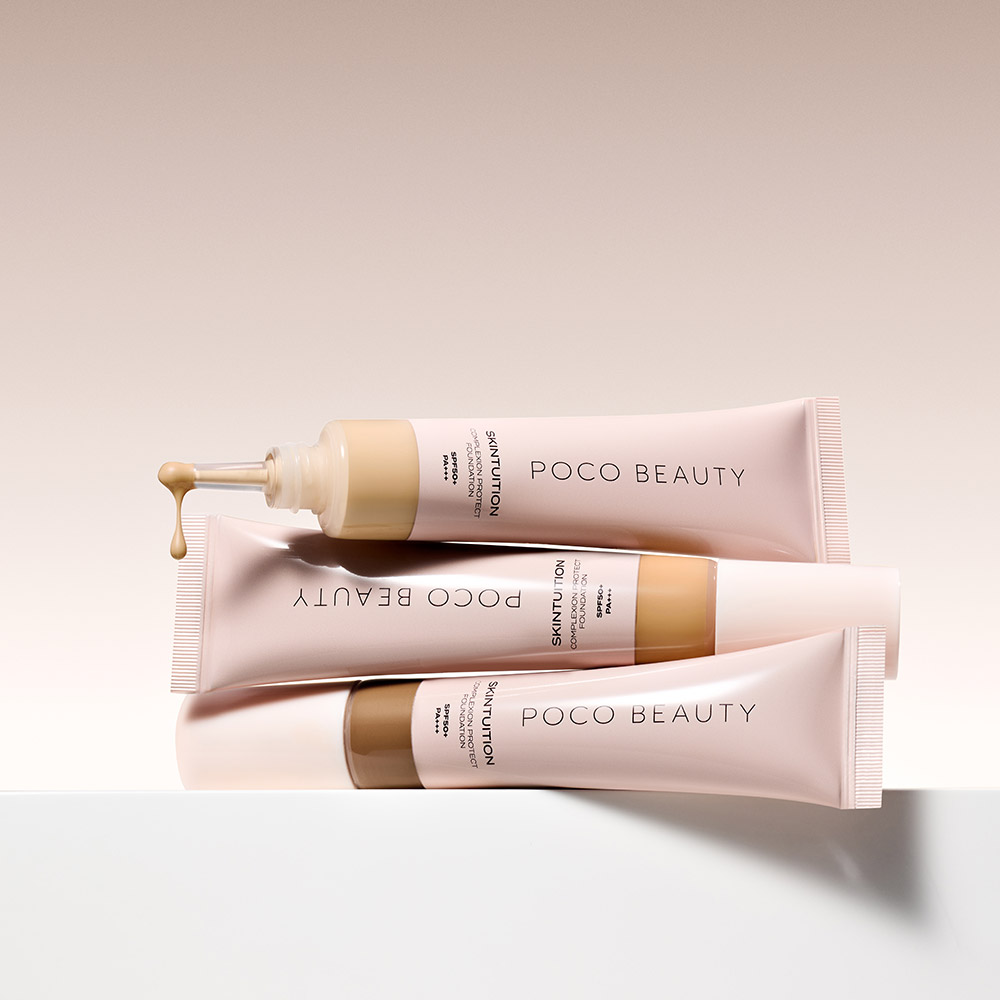 Three pink foundation tubes labelled Poco Beauty with gold accents displayed at angles on white surface