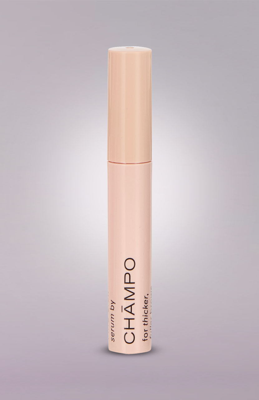 A beige cylindrical bottle labeled 'CHĀMPO serum for thicker' against a plain background.