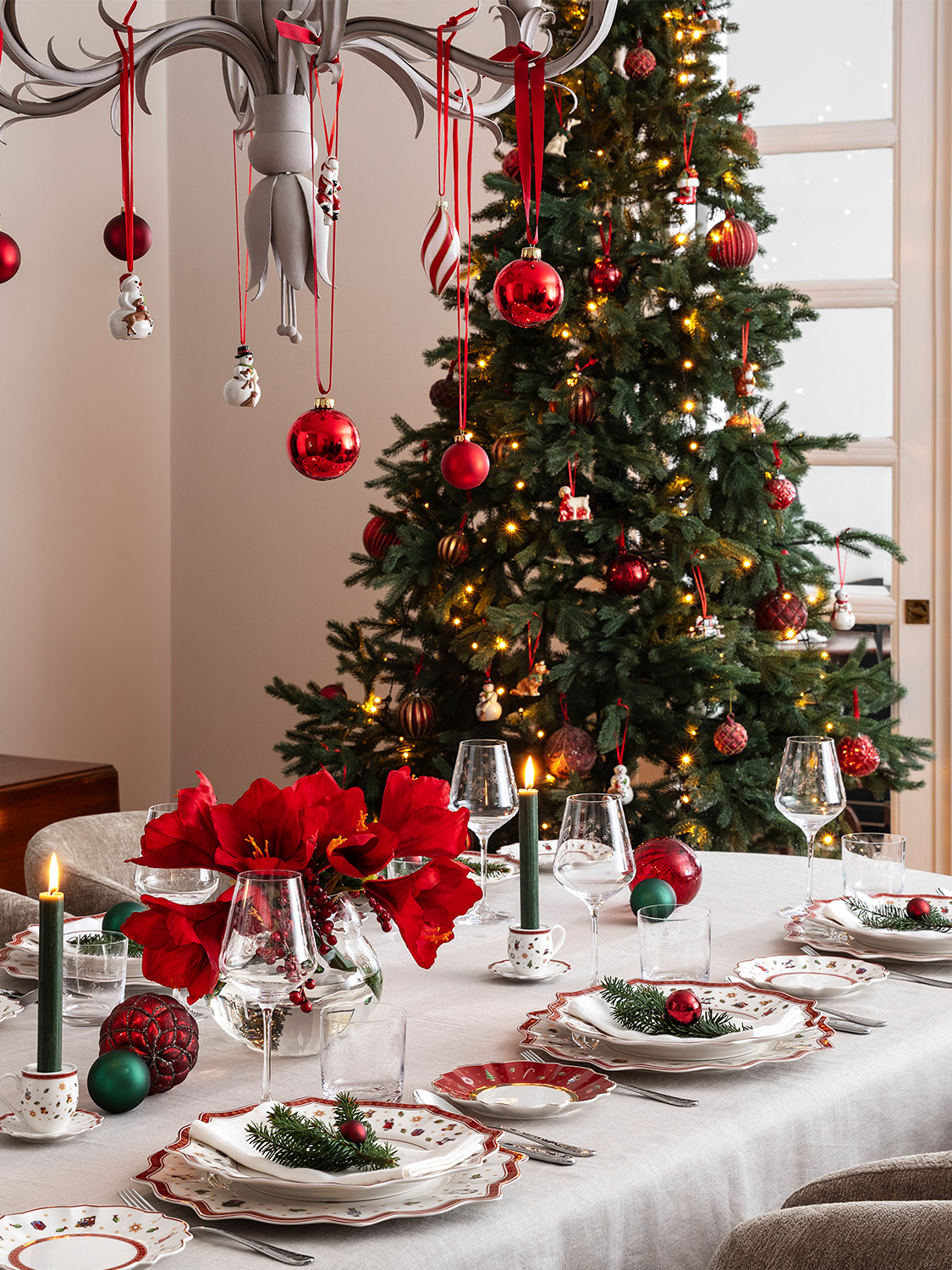 Festive dining room with a decorated Christmas tree and an elegant table setting.