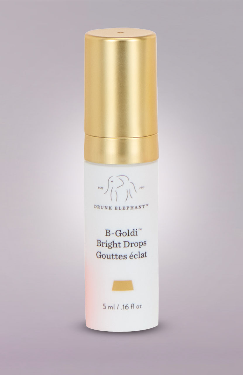 A small white bottle with a gold cap, labeled 'Drunk Elephant B-Goldi Bright Drops.'