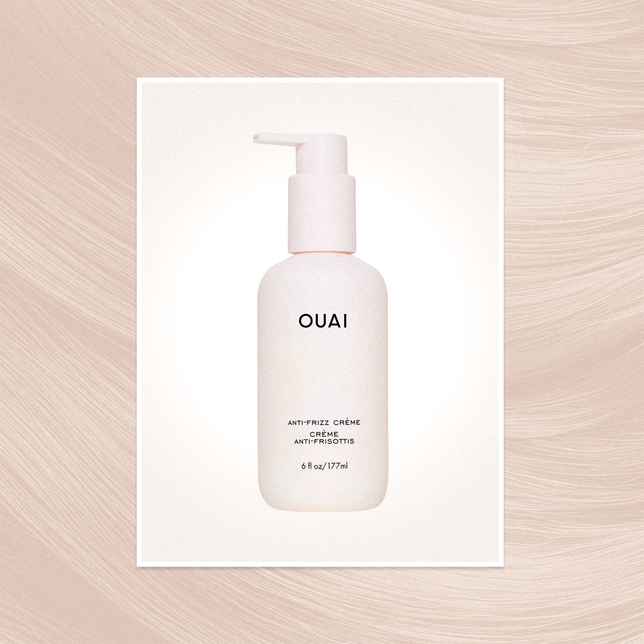 OUAI anti-frizz crème bottle with pump dispenser, displayed on cream card with textured background