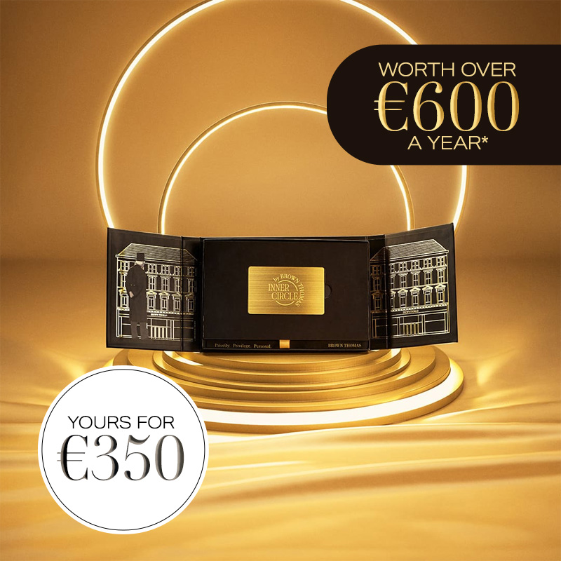 Black box containing a gold membership card displayed surrounded by lights on a gold background.