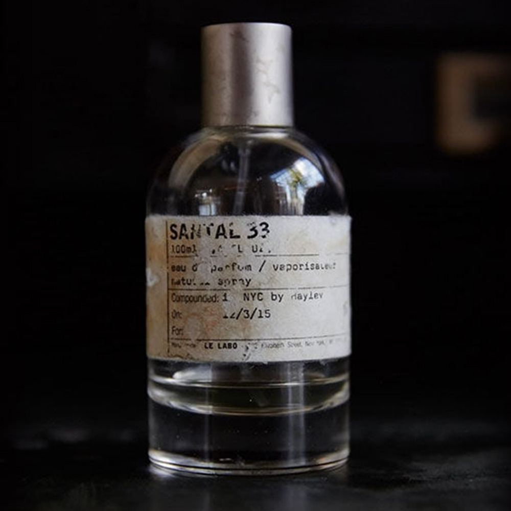 Santal 33 fragrance bottle with handwritten label on dark background