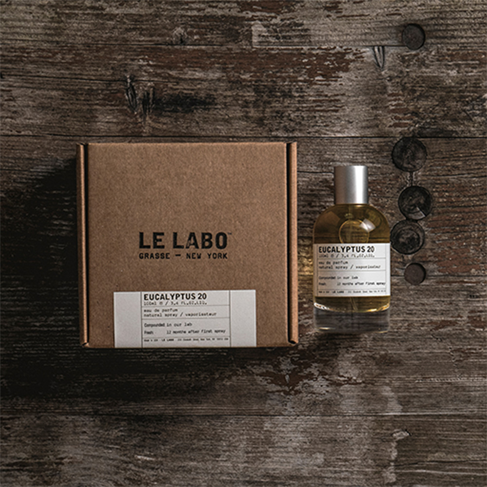 Eucalyptus 20 fragrance bottle and brown cardboard box on weathered wooden surface with decorative elements