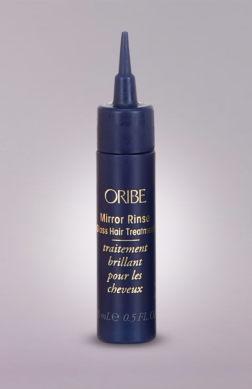 Dark blue hair treatment bottle with a pointed nozzle, labeled 'ORIBE Mirror Rinse Gloss Hair Treatment.'