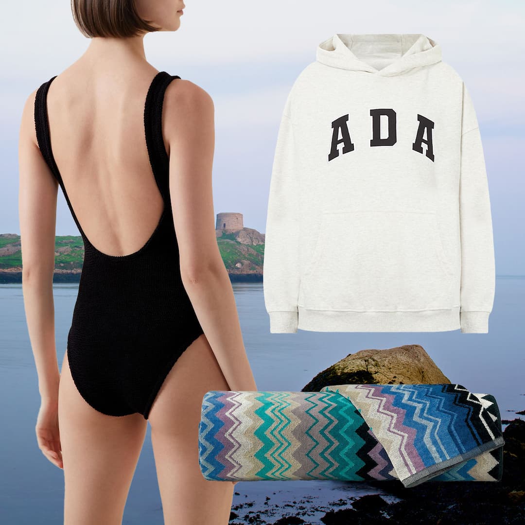 Woman wearing black ribbed one-piece swimsuit at coastal location