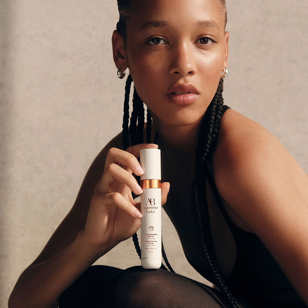 Woman holding sunscreen product with protective formula