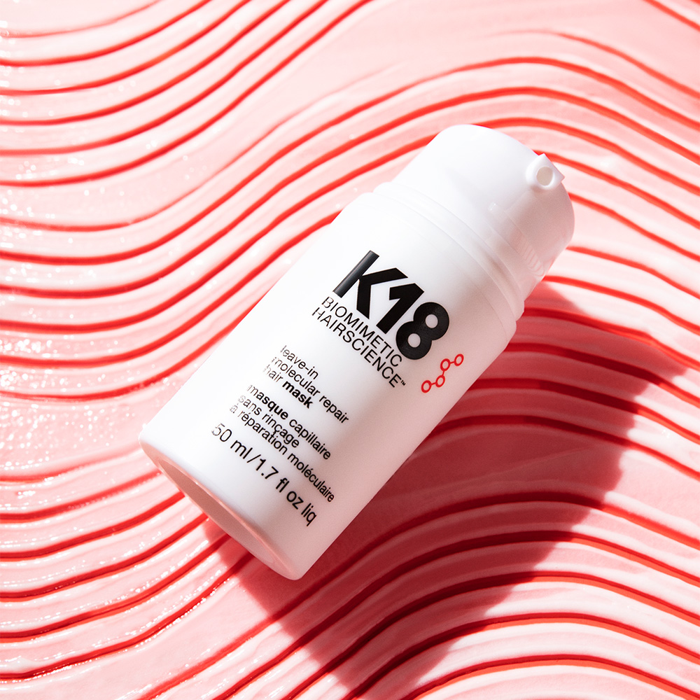 K18 leave-in molecule repair mask bottle on red wavy patterned background