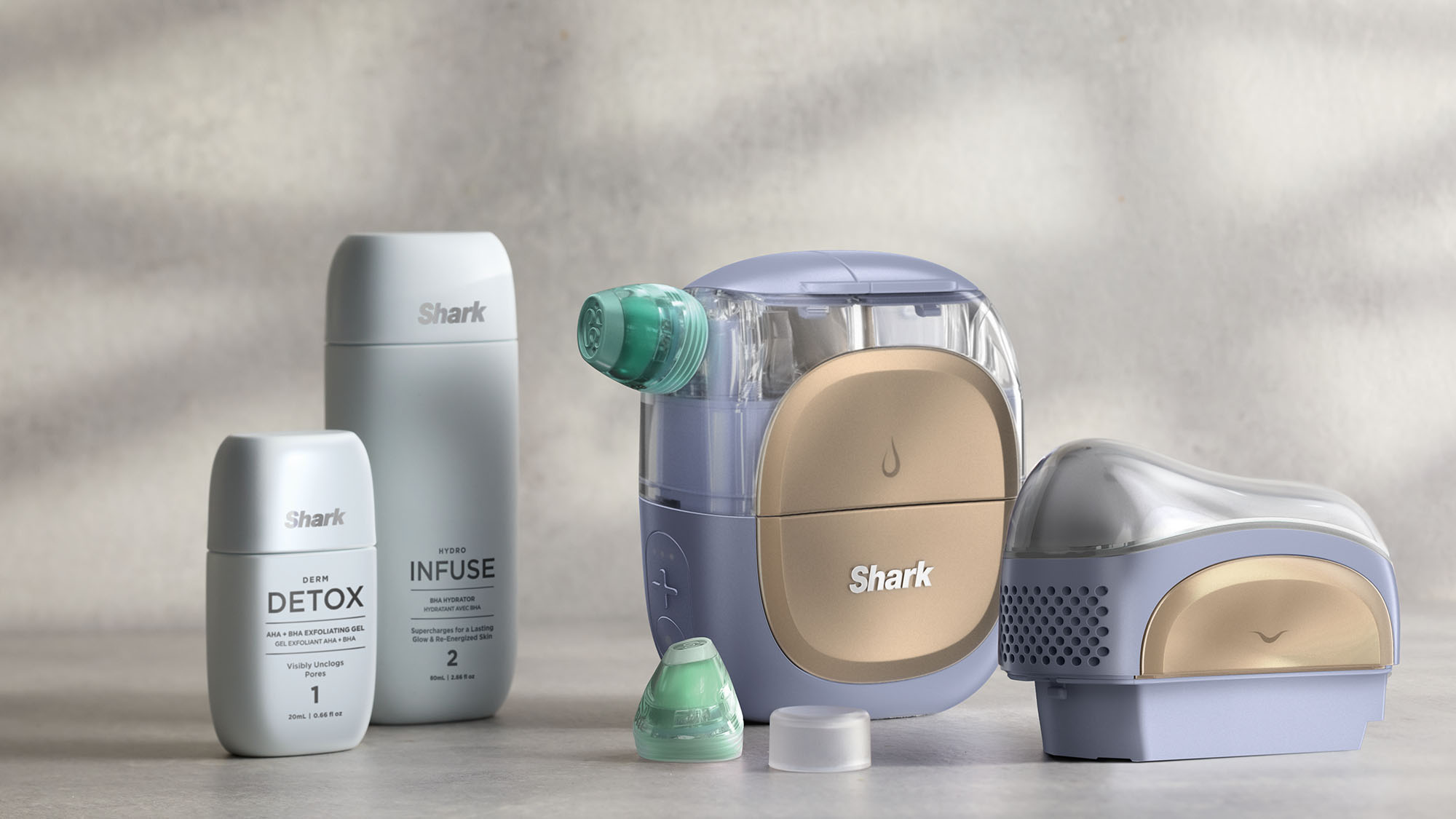 A collection of Shark brand cleaning products, including two bottles and two devices, displayed on a surface.