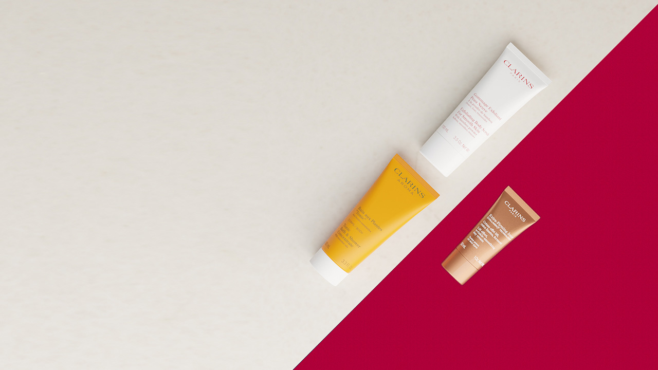 Three cosmetic tubes on a diagonally split beige and red background.