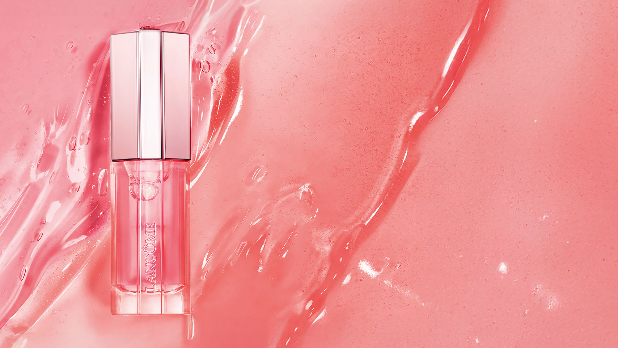 A pink lip gloss bottle on a textured pink background.