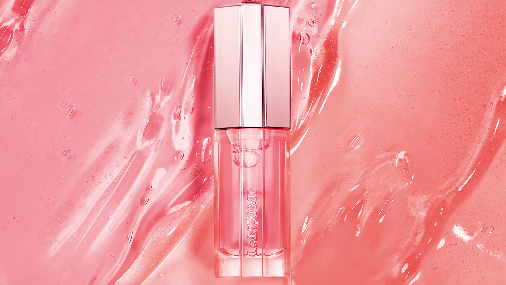 A pink lip gloss bottle on a textured pink background.