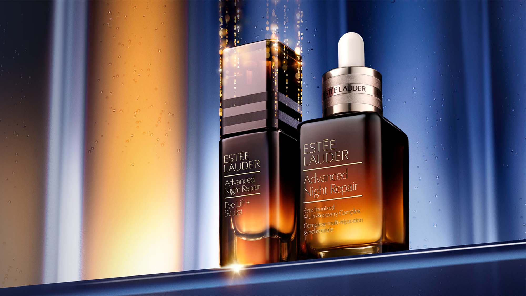 Two Estée Lauder Advanced Night Repair serum bottles against a dark, illuminated background.