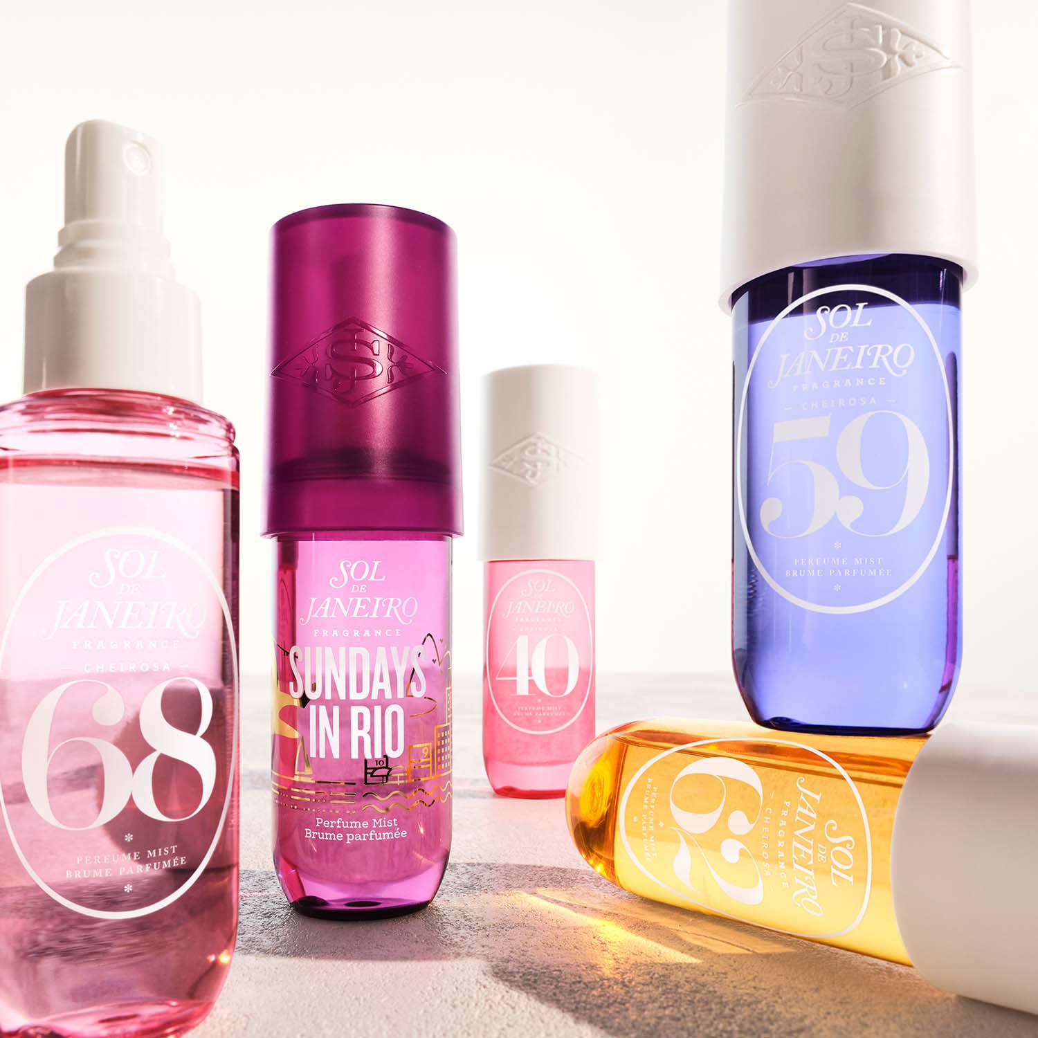 A collection of colorful Sol de Janeiro fragrance bottles with numbers and labels, arranged on a light surface.